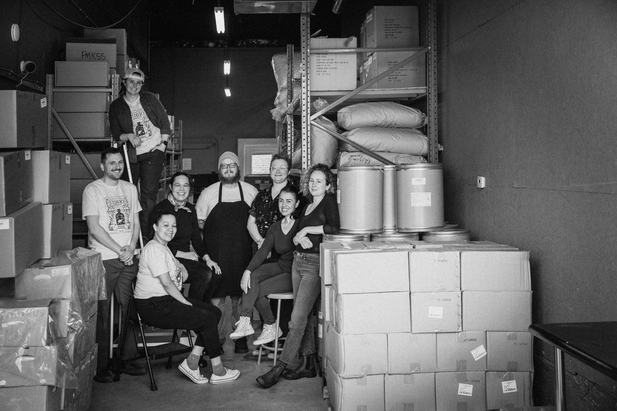 Curio Spice Co fulfillment team in a warehouse setting with boxes and equipment.